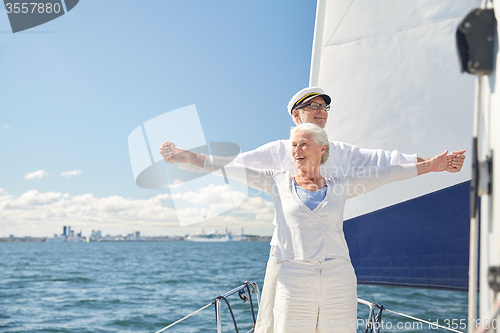 Image of senior couple enjoying freedom on sail boat in sea