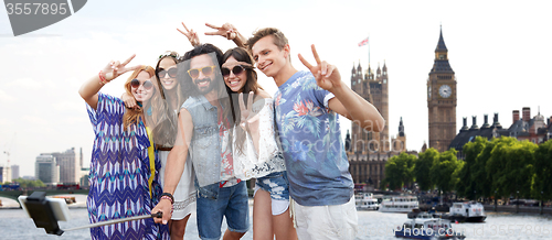 Image of smiling hippie friends with selfie stick in london