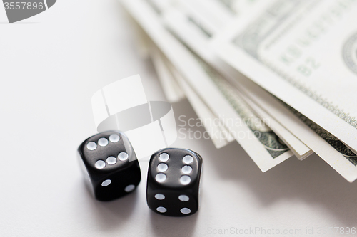 Image of close up of black dice and dollar cash money