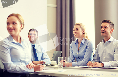 Image of group of smiling businesspeople meeting in office