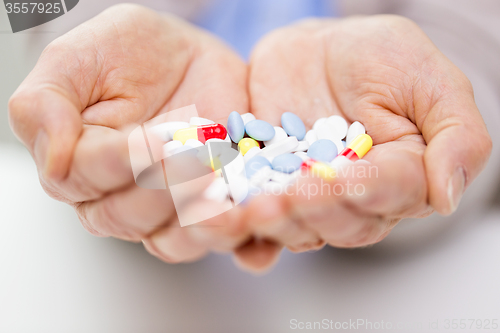 Image of close up of senior woman hands with pills