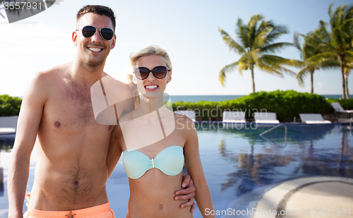 Image of happy couple in swimwear hugging over hotel resort