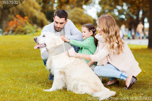 Image of happy family with labrador retriever dog in park