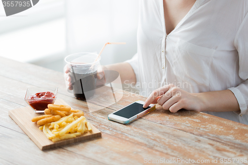 Image of close up of woman with smart phone and fast food