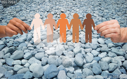 Image of hands holding people pictogram over stone desert