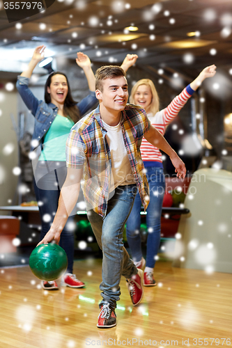 Image of happy young man throwing ball in bowling club