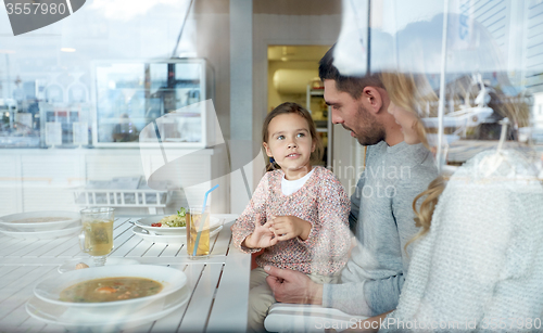Image of happy family having dinner at restaurant or cafe