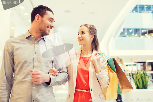 Image of happy young couple with shopping bags in mall