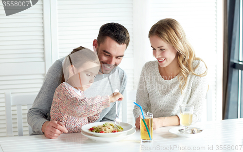 Image of happy family having dinner at restaurant or cafe