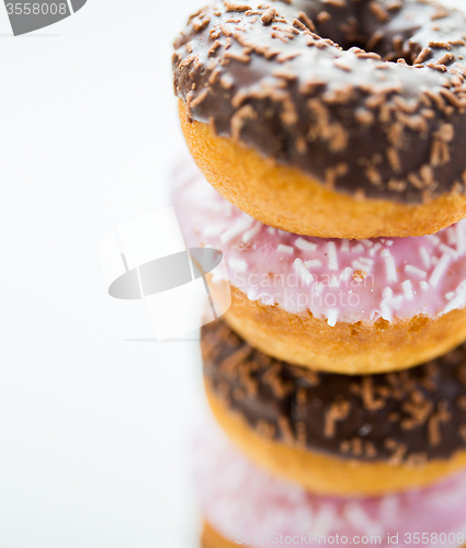 Image of close up of glazed donuts pile over white