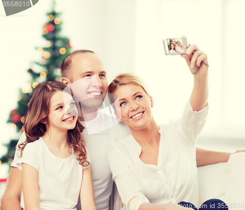 Image of happy family with camera at home