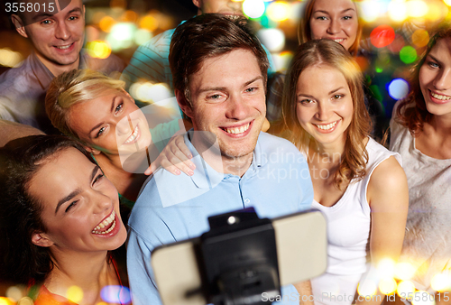 Image of friends with smartphone taking selfie in club