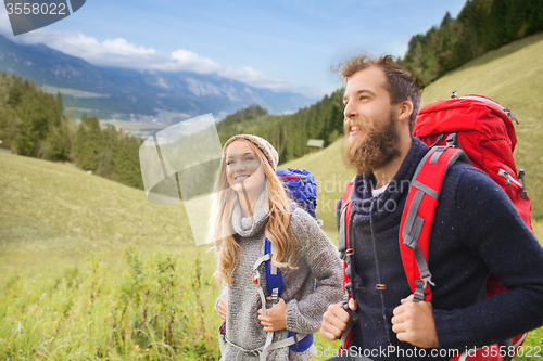 Image of smiling couple with backpacks hiking