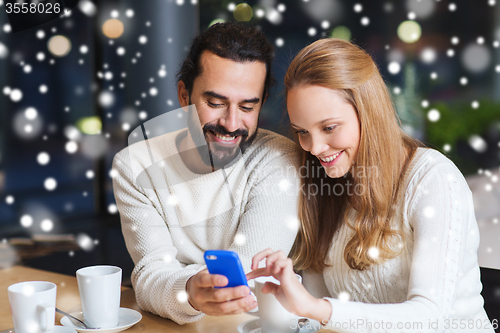 Image of happy couple with smartphone  and coffee at cafe