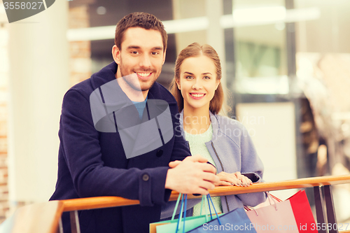 Image of happy young couple with shopping bags in mall