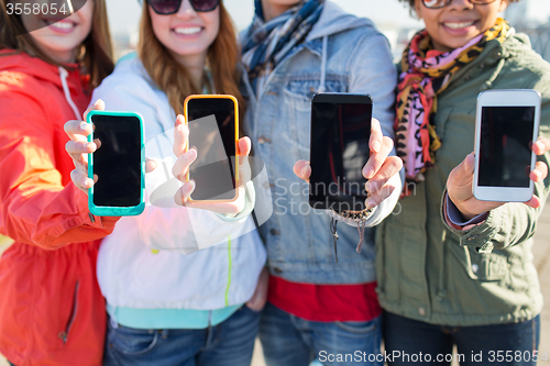 Image of close up of friends showing smartphone screens