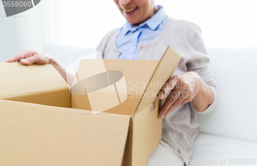 Image of close up of senior woman with parcel box at home