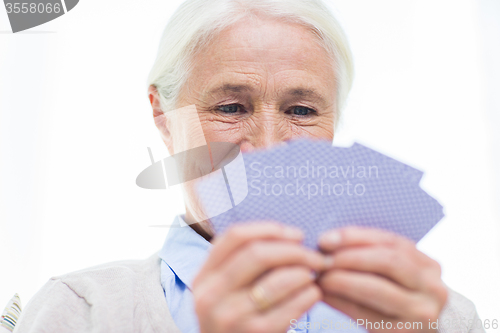 Image of close up of happy senior woman playing cards