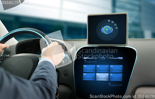 Image of close up of man with tablet pc driving car