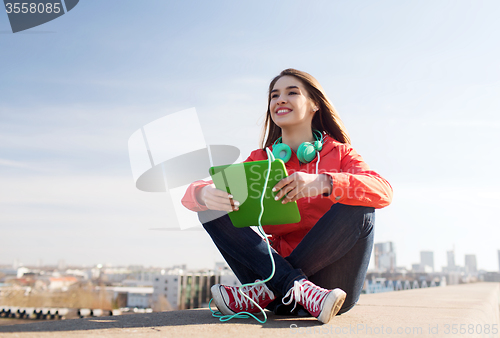 Image of happy young woman with tablet pc and headphones