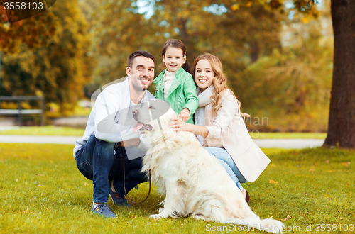 Image of happy family with labrador retriever dog in park