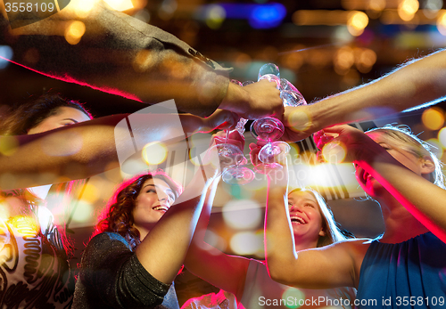 Image of smiling friends with glasses of champagne in club