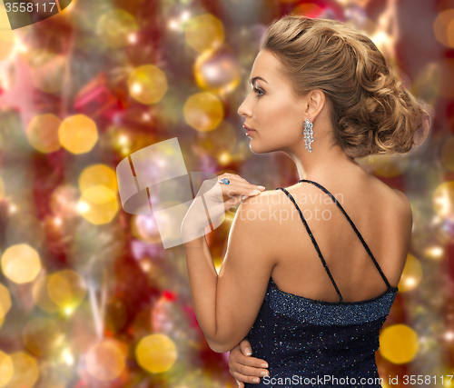 Image of beautiful woman with diamond earring over lights