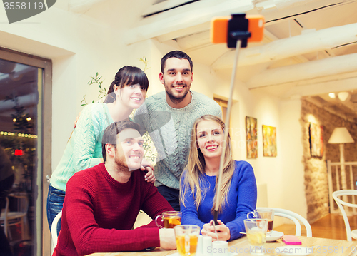 Image of group of friends taking selfie with smartphone