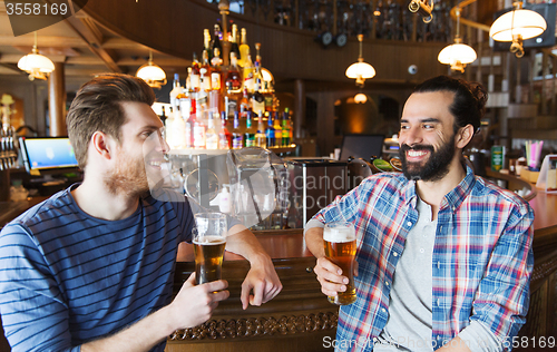 Image of happy male friends drinking beer at bar or pub