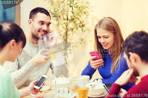 Image of group of friends with smartphones meeting at cafe