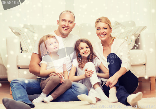 Image of smiling parents and two little girls at home