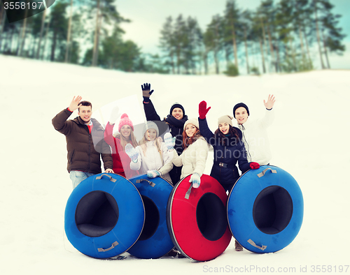 Image of group of smiling friends with snow tubes