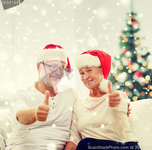 Image of happy senior couple in santa helper hats