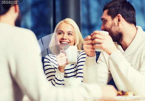 Image of happy friends meeting and drinking tea or coffee