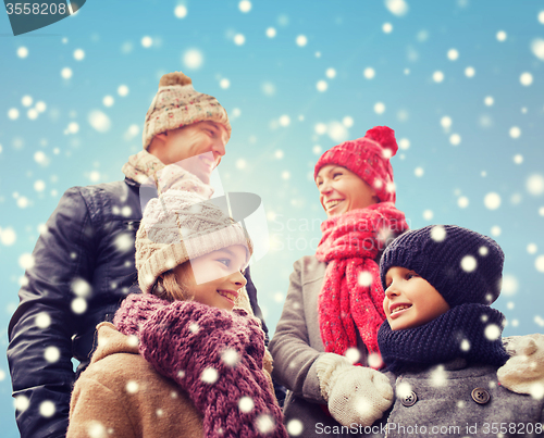 Image of happy family in winter clothes outdoors