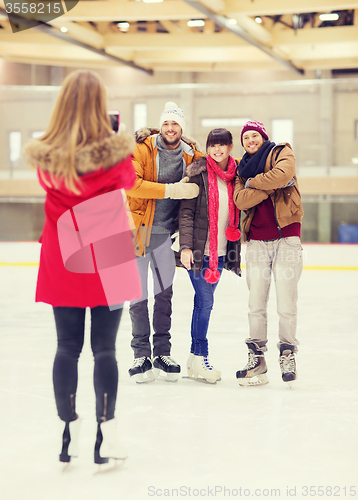 Image of happy friends taking photo on skating rink