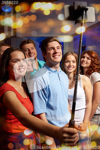 Image of friends with smartphone taking selfie in club