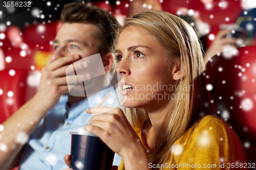 Image of friends or couple watching horror movie in theater