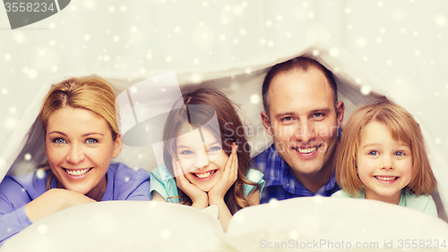 Image of happy family with two kids under blanket at home