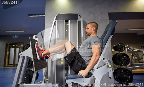 Image of man flexing leg muscles on gym machine