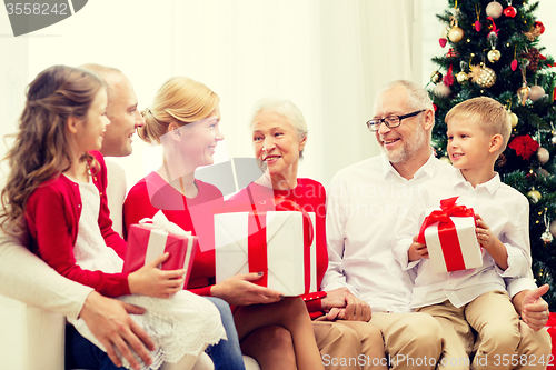 Image of smiling family with gifts at home