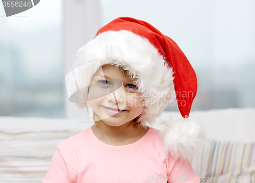 Image of smiling little girl in santa hat at home