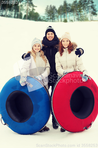 Image of group of smiling friends with snow tubes