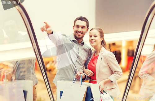 Image of happy young couple with shopping bags in mall