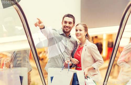 Image of happy young couple with shopping bags in mall