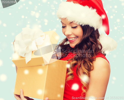 Image of smiling woman in santa helper hat with gift box