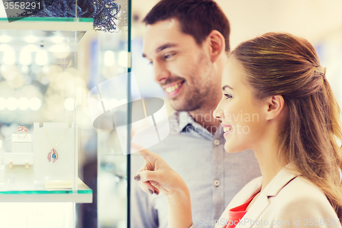 Image of couple looking to shopping window at jewelry store