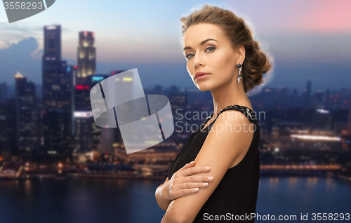 Image of beautiful woman wearing earrings over night city