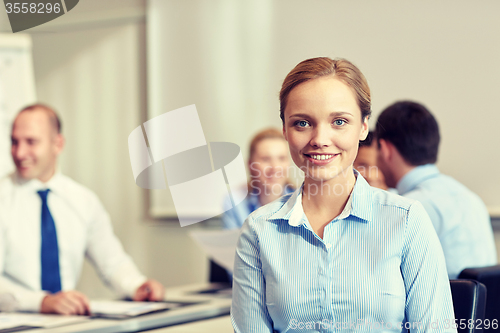 Image of group of smiling businesspeople meeting in office