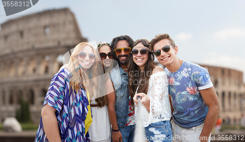 Image of happy hippie friends with selfie stick at coliseum